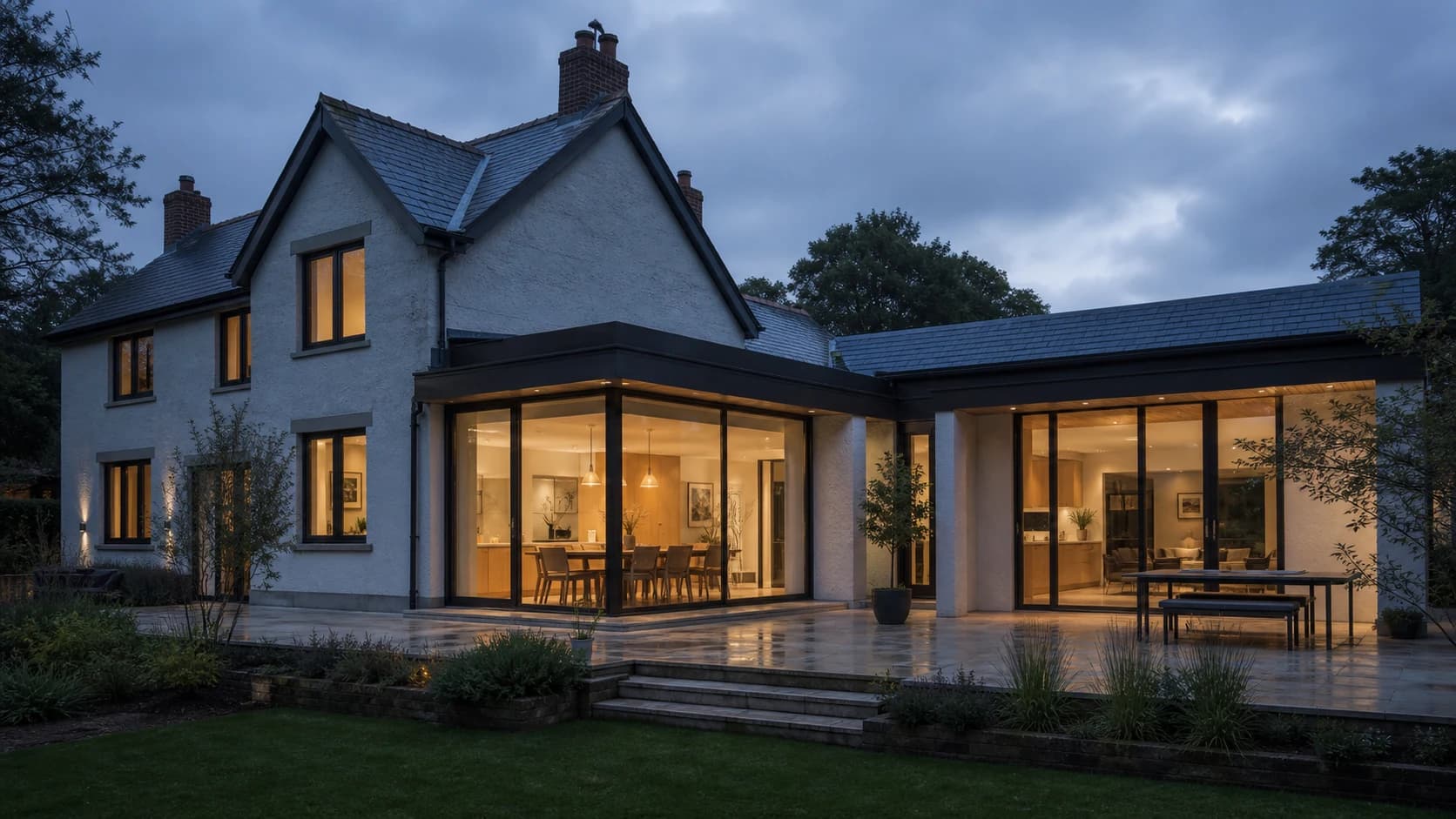 Design visualisation of a renovated South Wales home with a glazed side and rear extension at dusk